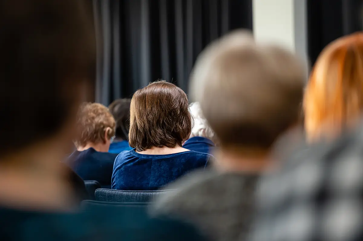German-Consultation Audience members seated at a public participation or stakeholder engagement event, viewed from behind